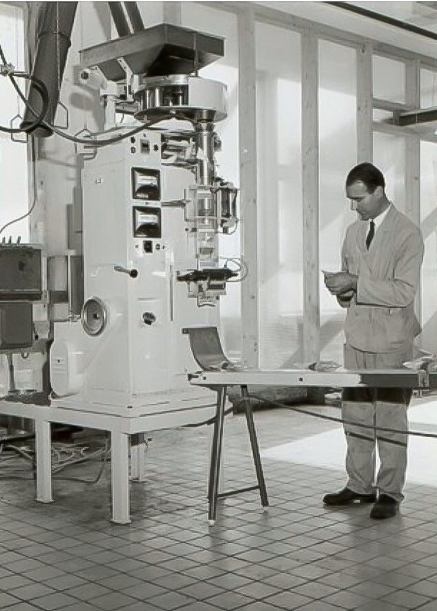 Notenbrander H. Derwort bij een inpakmachine in de Calvéfabrieken aan de Wateringseweg, 1965
