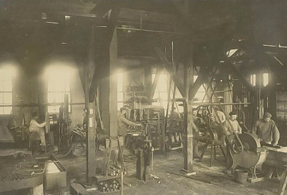 Fabrieksarbeiders aan het werk in de smederij van Calvé aan de Wateringseweg met in het midden meester P.F. Smeele. 1900