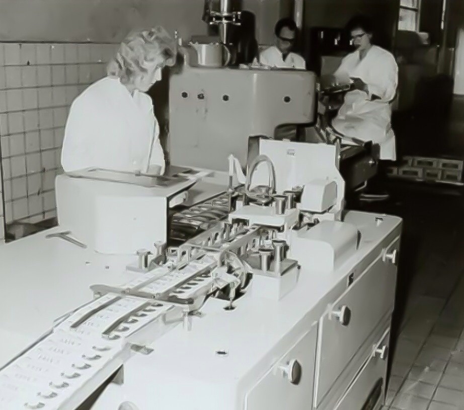 Medewerksters aan de lopende band mayonaisetubes in de Calvéfabrieken aan de Wateringseweg, 1965