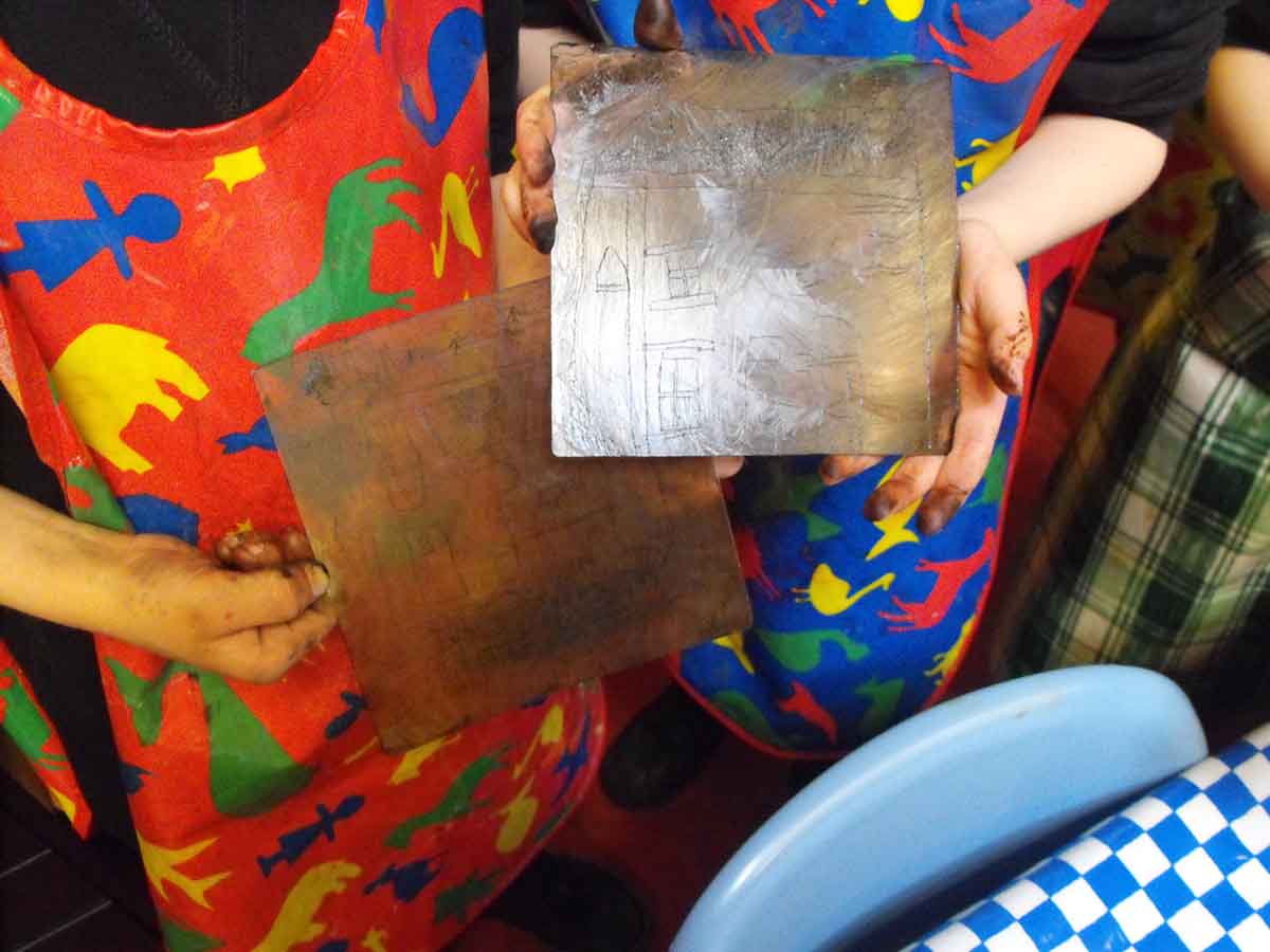 Pupils showing their etching plates at a school printmaking workshop