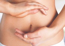 Frau hält die Hände in einem Kreis vor ihren Bauch