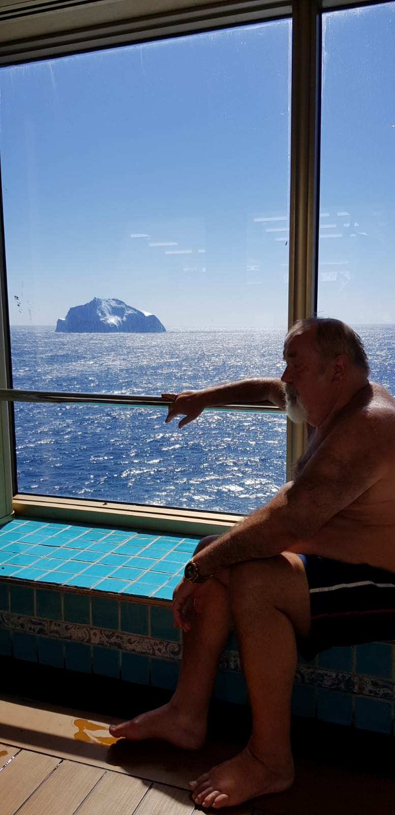 Peter auf dem Pooldeck und das Schiff fährt vorbei am Eisberg