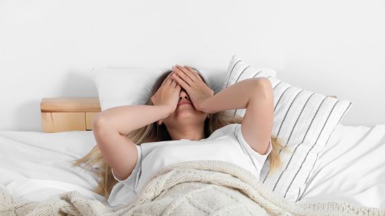 Frau, die erschöpft im Bett liegt