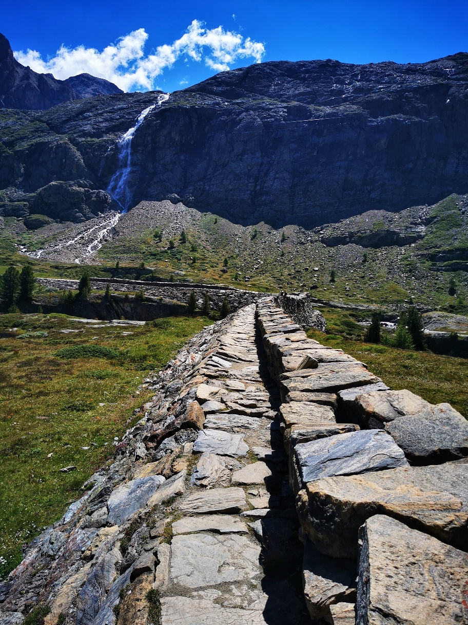 Über eine alte Staumauer führt der Weg Richtung Wasserfall