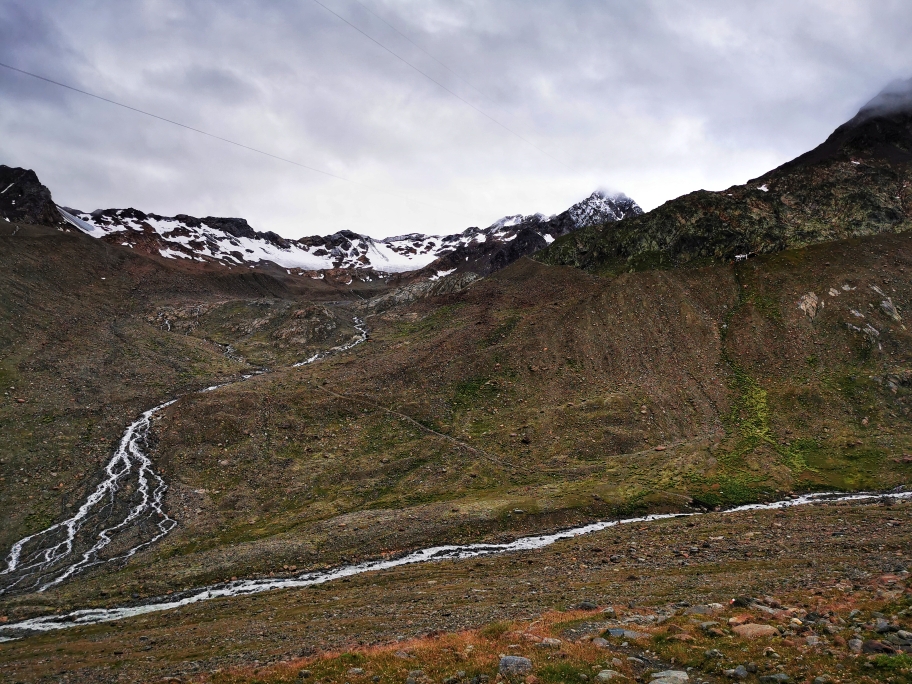 Oben links die Guslarspitzen, oben rechts kommt die Hütte in Sicht. Zunächst muss unten aber der Gletscherbach überquert werden