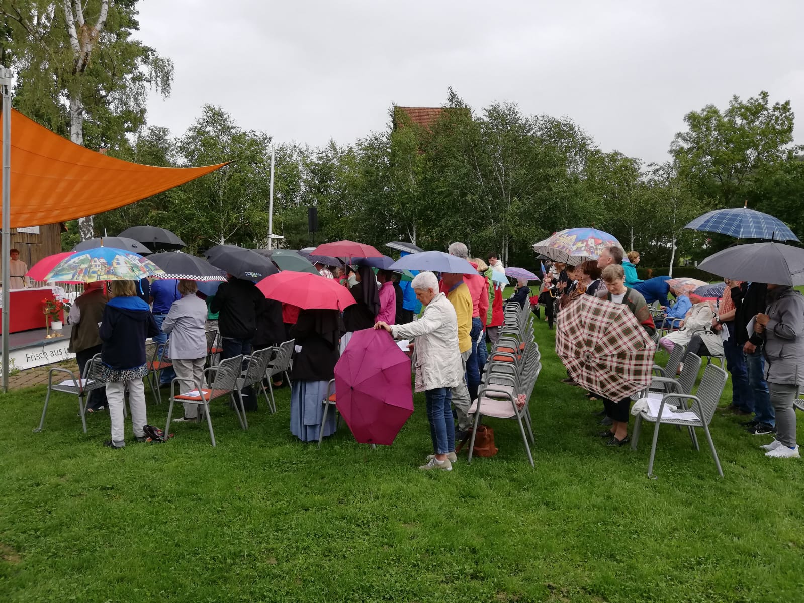 ... und während der Predigt öffnet der Himmel seine Schleusen ... und die Teilnehmer die Regenschirme Foto: M. Zörner