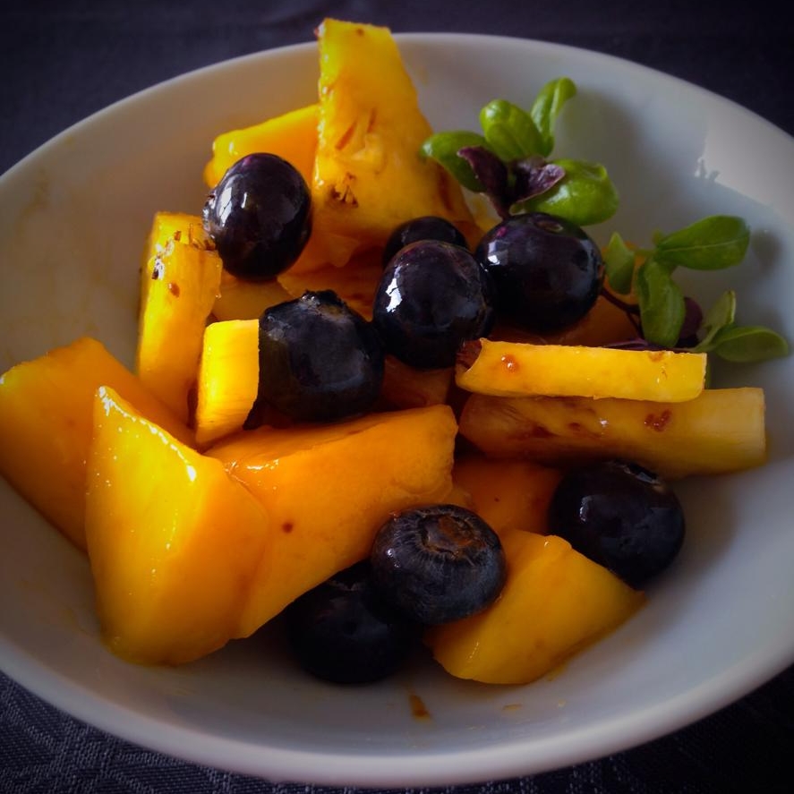 Salade de fruits fraîcheur : ananas, mangue, myrtilles, sucre de coco et duo de jeunes pousses de basilic (vert et violet) 