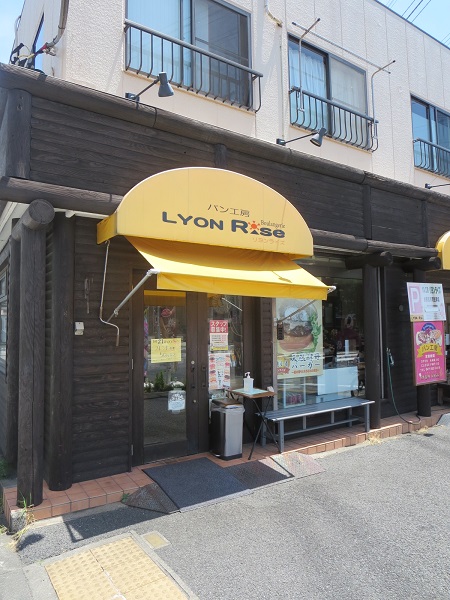 リヨンライズのポテトサラダとスパイシーベーコンの看板と入口。
