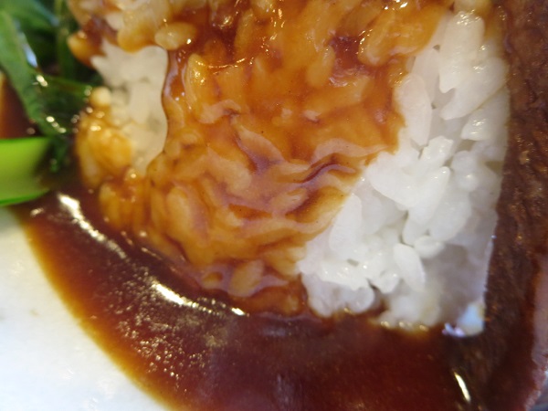 萬福の豚角煮丼のタレのかかったご飯の近影画像。
