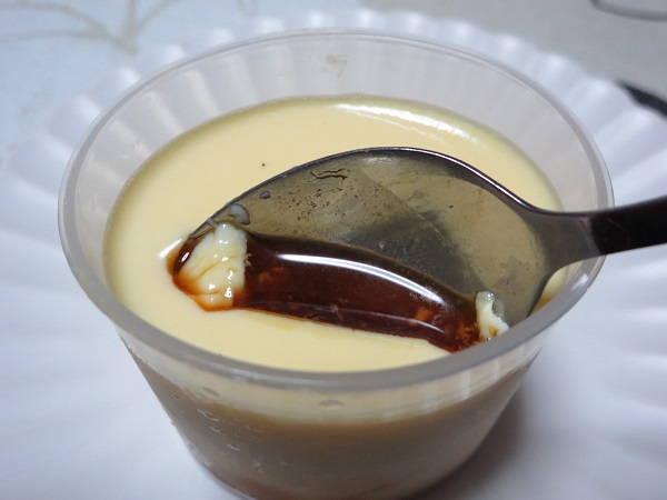 コッコきみまろのコッコプリンのカラメルをスプーンで掬った近影画像。