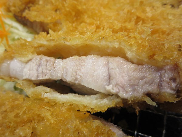 とんかつ菊万の国産プレミアムリブカツ定食のロースかつの断面の近影画像。