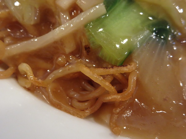辣碗のあんかけ五目焼きそばの焼き目のついた麺の近影画像。