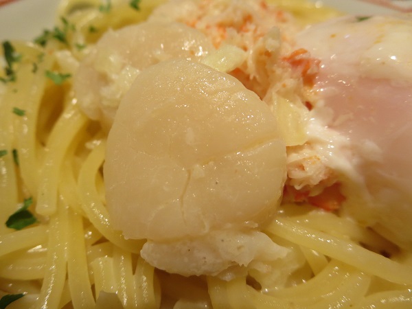 洋麺屋 五右衛門の紅ズワイガニと帆立のクリームソース温泉卵添えの帆立の近影画像。