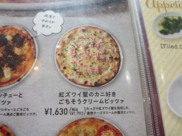 パステルイタリアーナの紅ズワイ蟹のカニ好きごちそうクリームピッツアが記載されている店内のメニュー。