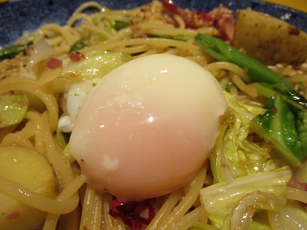 洋麺屋 五右衛門のイベリコ豚と春野菜づくしのよくばりスパゲッティーの温泉玉子の近影画像。