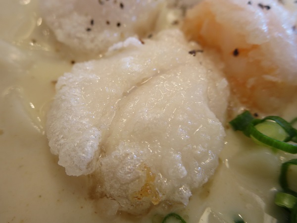 とんでんの海鮮ごろっと白いカレーうどんのホタテの近影画像。