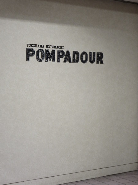 ポンパドウルの店舗の壁に掲げてあるロゴ。