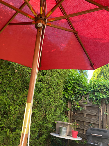roter Sonnenschirm auf Terrasse