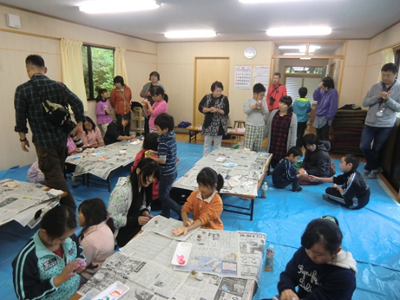 場所を真滝3区集会所に移しての午後のモノ作り体験。粘土のようなものを丸めたボール状のものをこねた「つるぴか玉」と色を付けた「地球玉」の二つにチャレンジ!