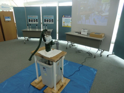 スクリ^ンに移された屋内浸水をポンプでくみ上げる体験