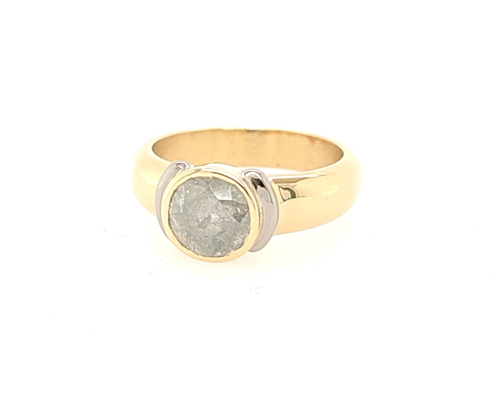 Un diamant très "poivré" est mis en valeur par ce montage rond et bicolore - or jaune 750 et or gris palladié 750