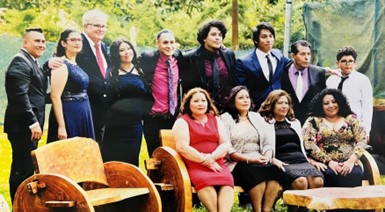 Picture of Claudia and her whole family gathered together to pose for a wedding picture at her niece's wedding.