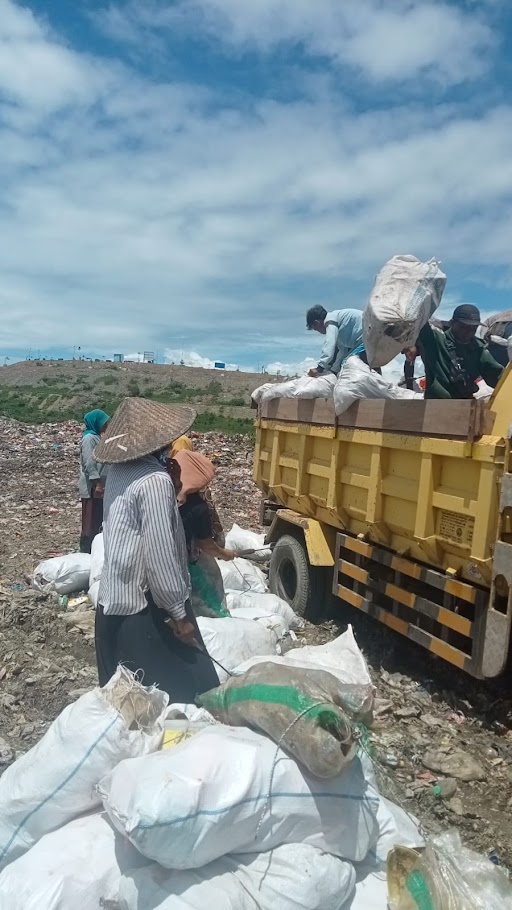 Müllhalde in Kebong Kongok. Viele Menschen verdienen hier Geld, indem sie den Müll recyclen. Bulldozer verdichten den Müll zu einem Berg.