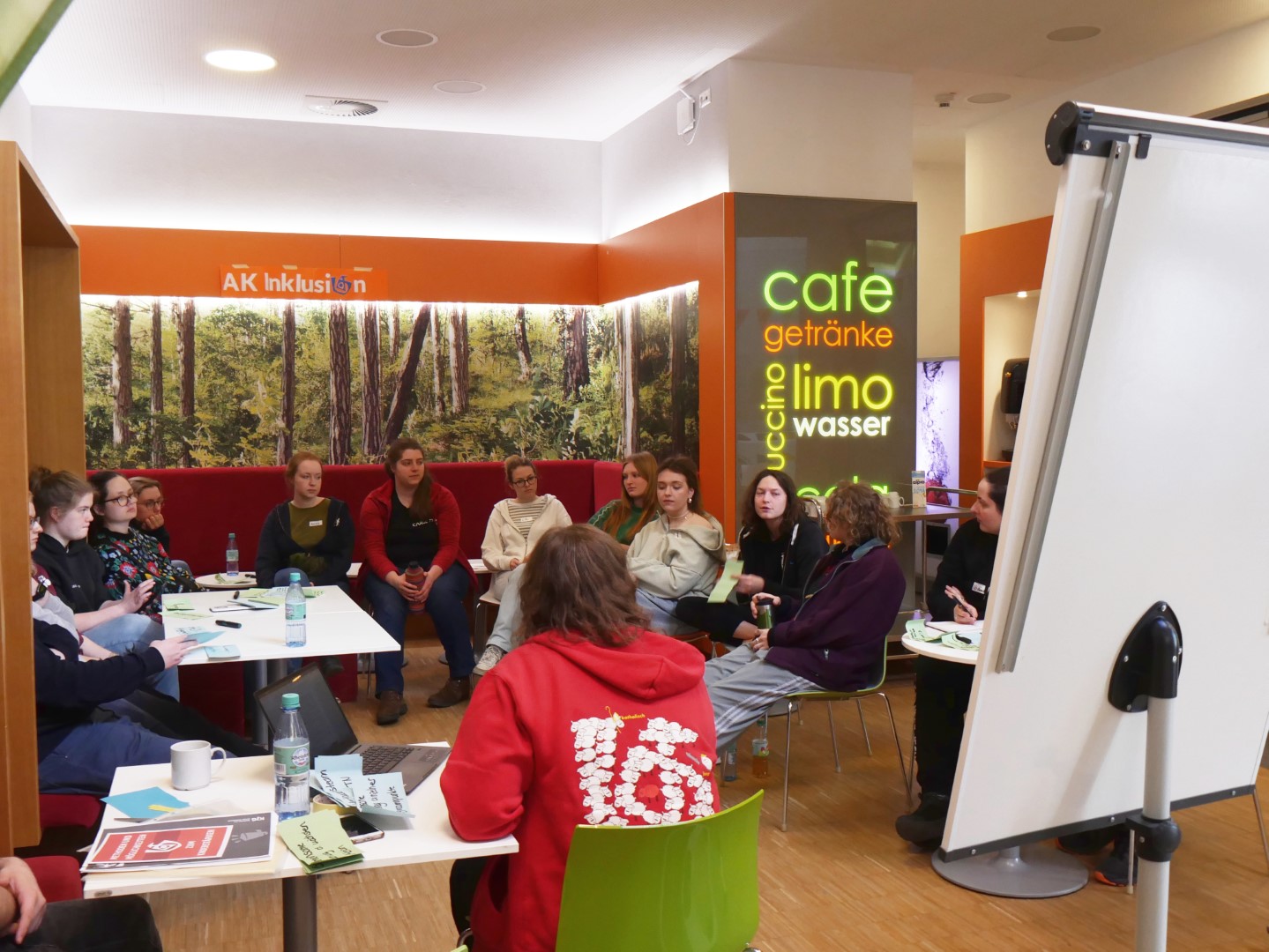 Im Bistro schaut sich eine Gruppe Methoden vom Kinder- und Jugendgipfel LautStark an.