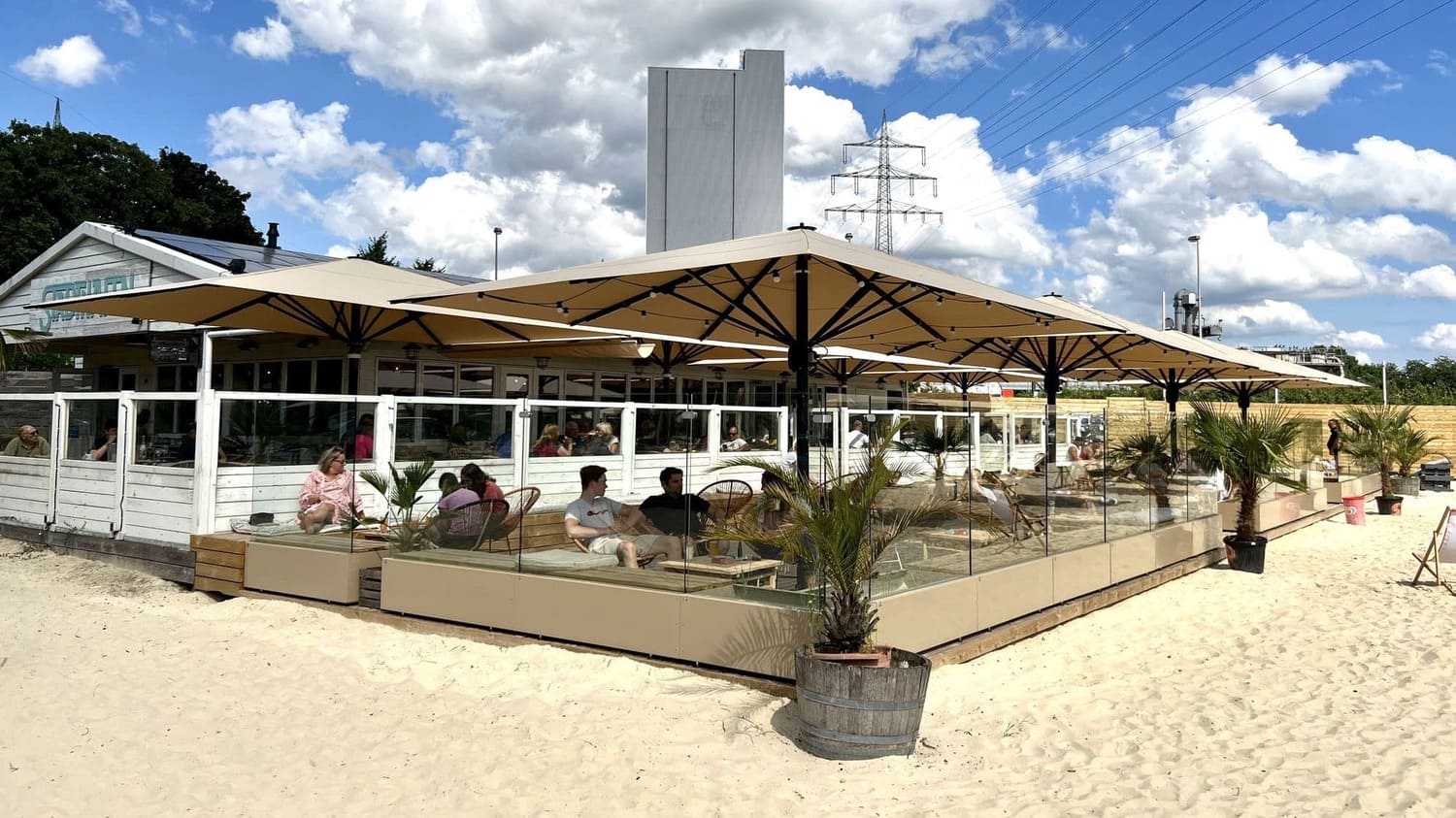 Glas-Windschutz für Beachclubs – langlebiger Wetterschutz für mehr Umsatz durch windgeschützte Lounges im Sandbereich