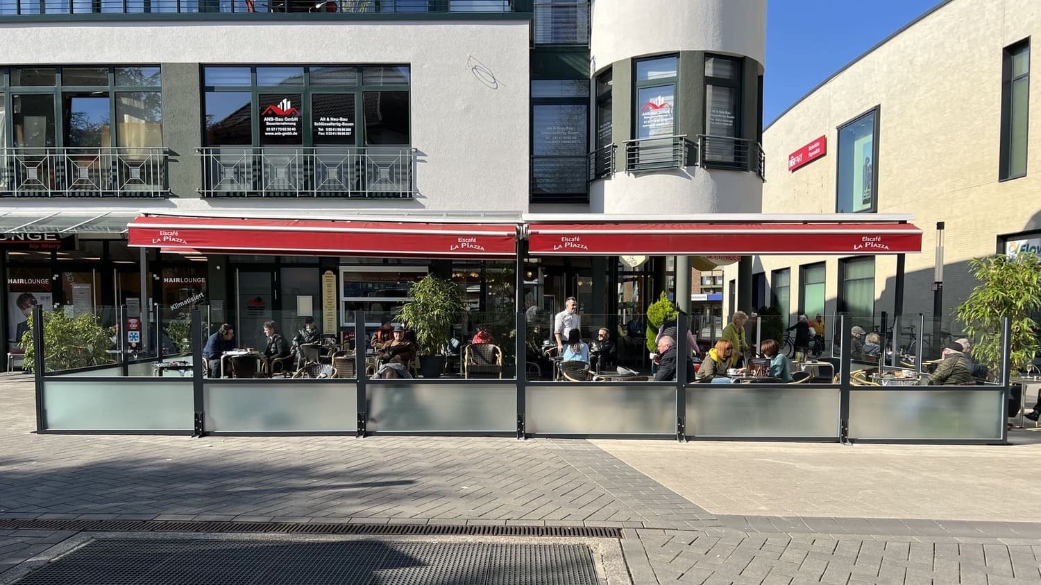 Starre Windschutzwand mit satiniertem Glas-Sichtschutz für Eiscafés – fest installierte Terrasseneinfassung auf gepflastertem Grund