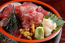a bowl of rice topped with slices of raw tunas