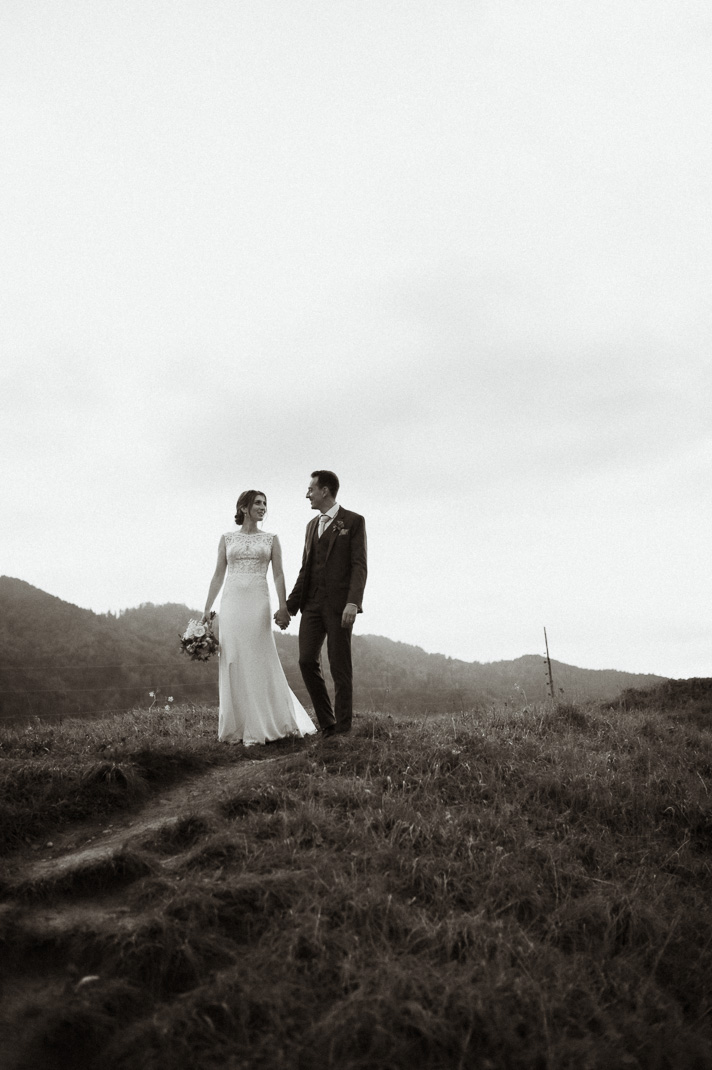 cooles Hochzeitsbild beim Brautpaarshooting, das Brautpaar sieht sich an und im Hintergrund sind Berge zu sehen.