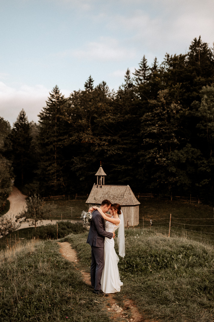 Das Brautpaar umarmt sich innig bei seinen Brautpaarfotos am Schliersee.