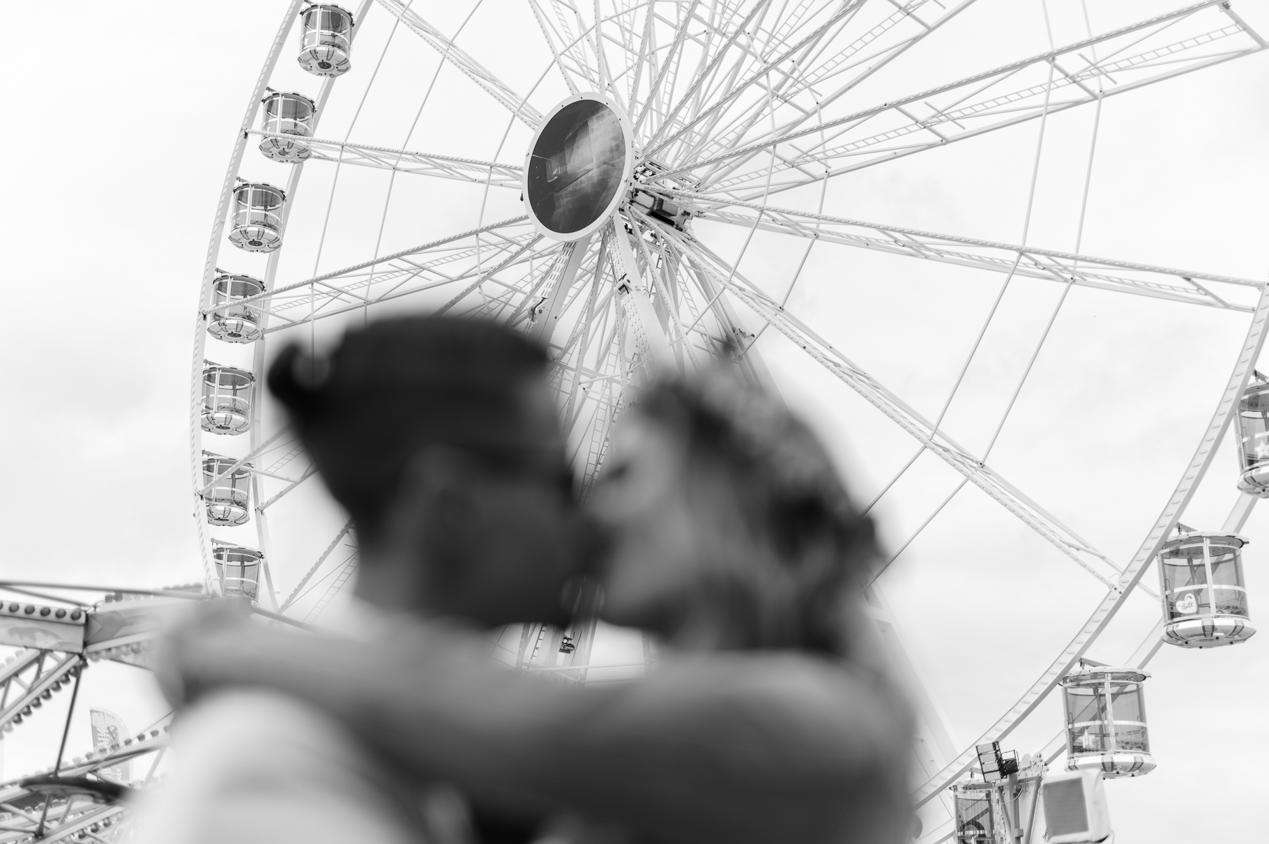 Paar küsst sich unscharf vor dem Riesenrad auf dem Volksfest in Erding
