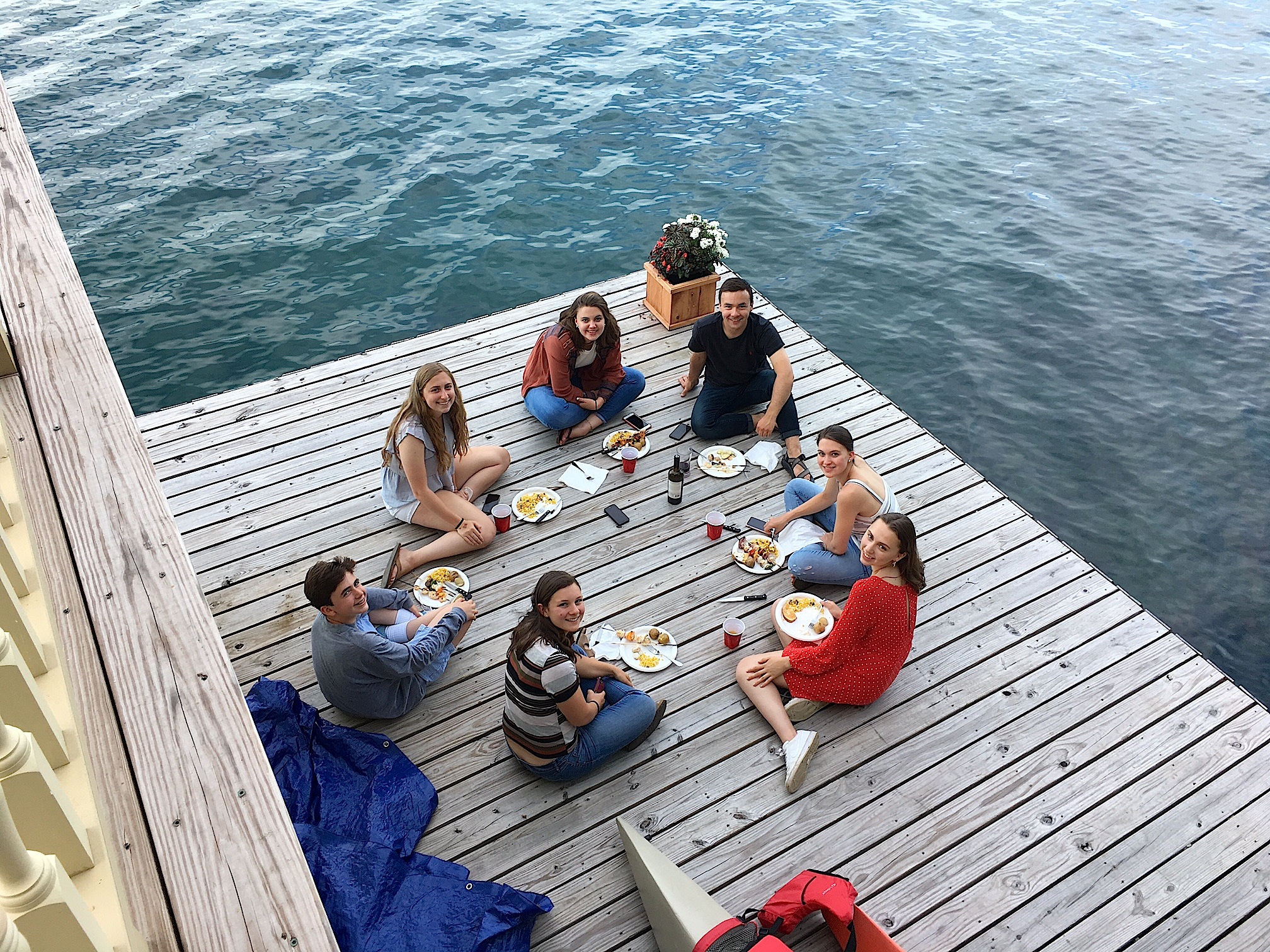 The teens eat dinner on the dock