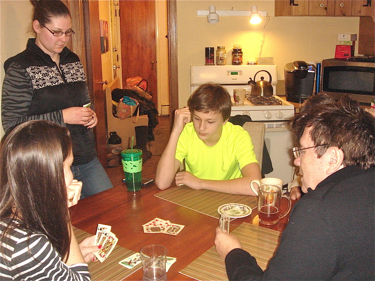 Ellie, caregiver Jesika, Jack Kagel learn Euchre from John Wagner