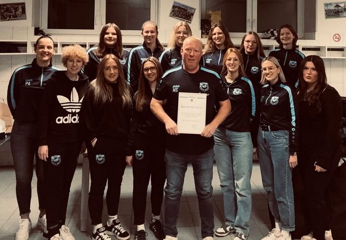 Das ganz neu eingekleidete Damen-Team überbringt Trainer Michael "Opa" Schäfer eine Urkunde als "Sportler des Jahres".