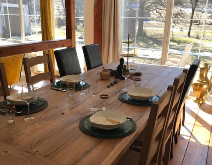 Massiver rustikaler Eichentisch mit Holzstühlen in einem gemütlichen Esszimmer, ideal für ein einladendes Ambiente.