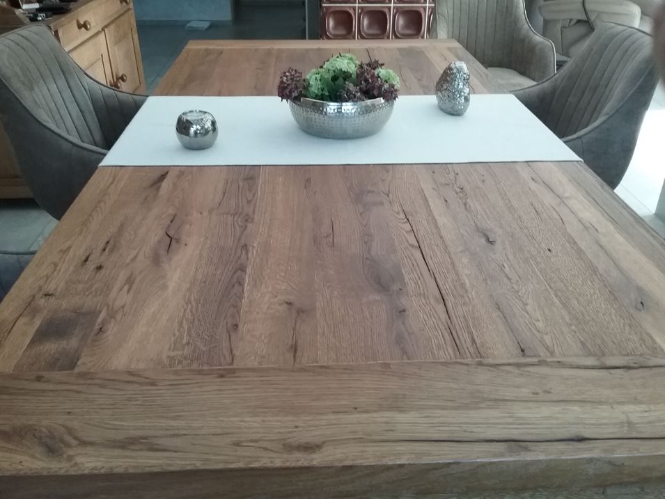Detailbild einer Tischplatte aus Eiche Altholz mit sichtbaren Rissen und Maserungen.