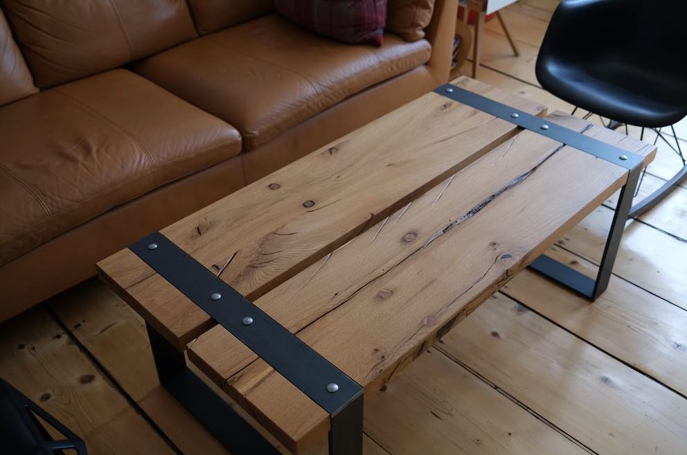 Couchtisch aus Eiche Altholz mit umlaufendem Flachband-Tischgestell aus Rohstahl, rustikales und modernes Design.