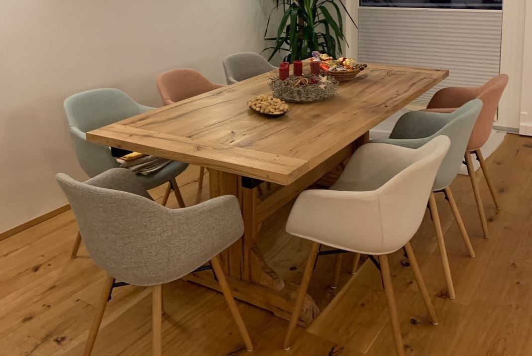 Moderner Klostertisch aus Eiche Altholz kombiniert mit gemütlichen Schalenstühlen im Chalet-Stil, perfekt für Chalets und Berghütten in den österreichischen Alpen.