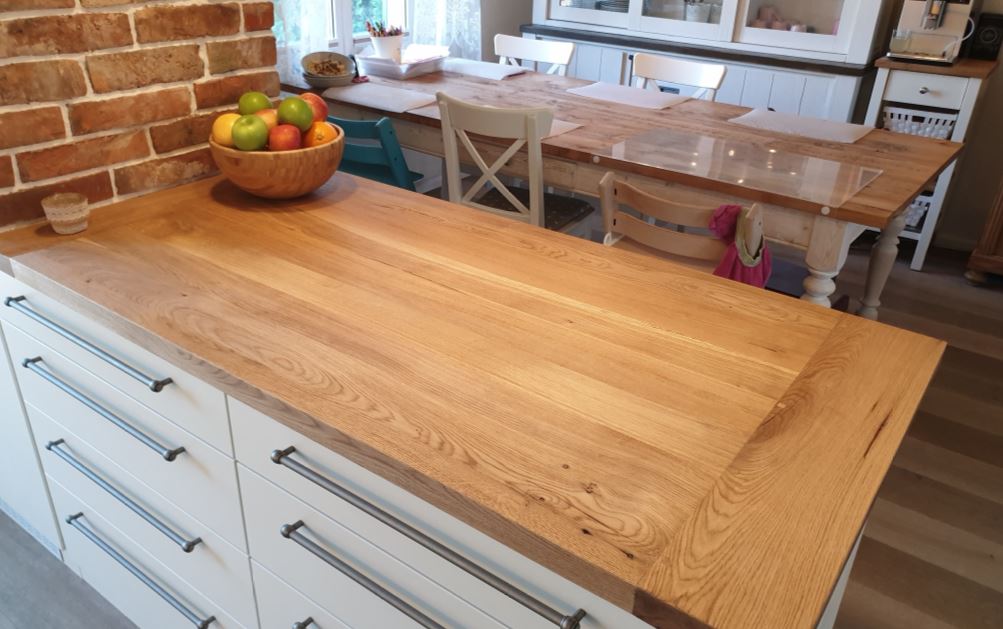 Tischplatte aus Altholz mit markanten Rissen und Ästen. Rustikales Design für die Landhausküche.