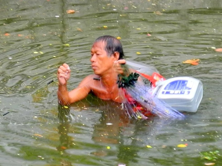 Nahrungssuche - Thai beim Fischfang in einem Khlong