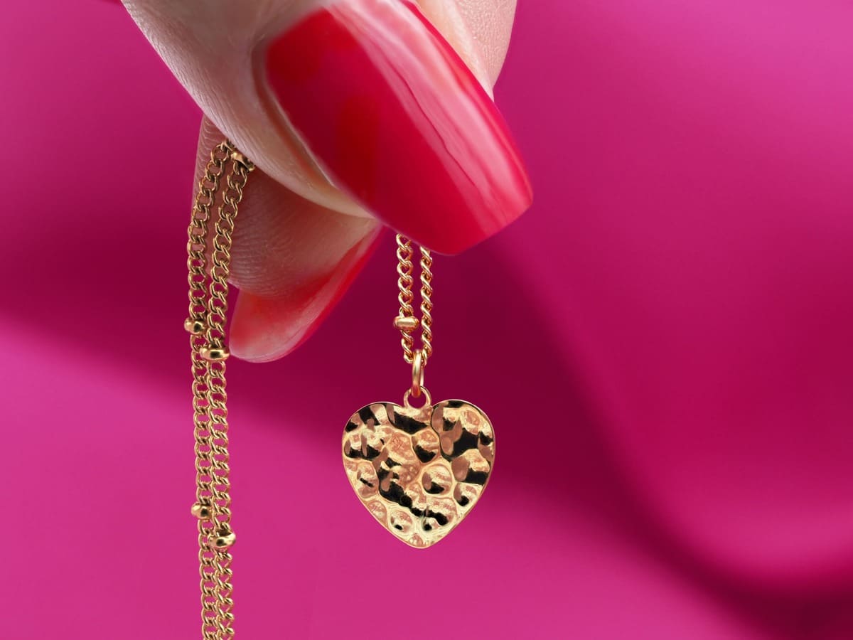 <img src="Filigrane-Satelliten-Kette-gold-Kugeln-gehämmertes-Herz-Edelstahl-pink.jpg" alt="Filigrane Satelliten Kette gold mit gehämmertem Herz Anhänger aus Edelstahl auf pinkem Hintergrund" />