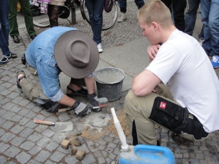 Der Stolperstein wird eingelassen und verfugt