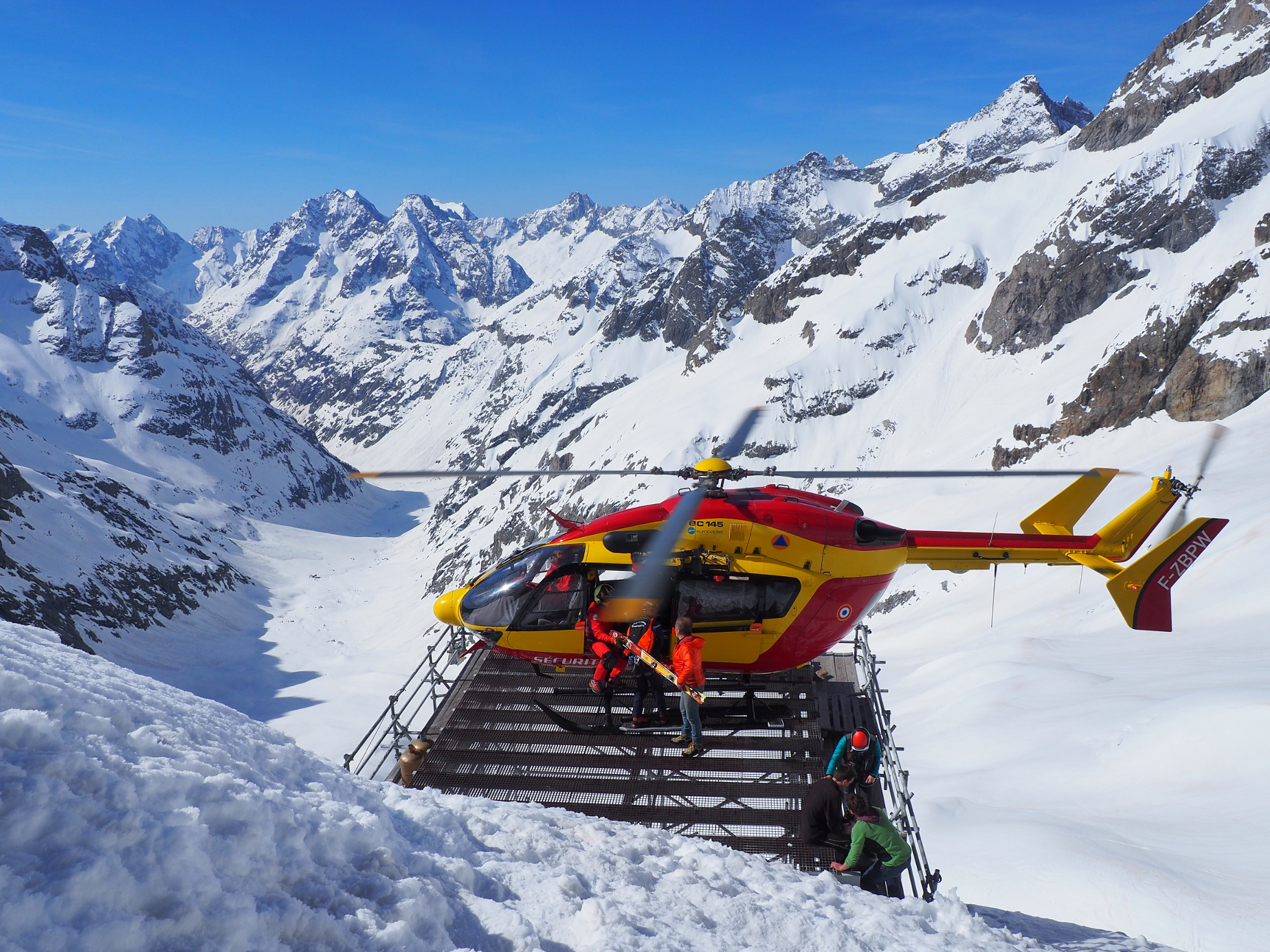 Un skieur s'est fait une luxation de la rotule et a sans doute touché ses ligaments croisés. Sur la DZ, médecin et secouristes accompagnent le bléssé pendant que nous rentrons dans l'hélico son sac et ses skis.