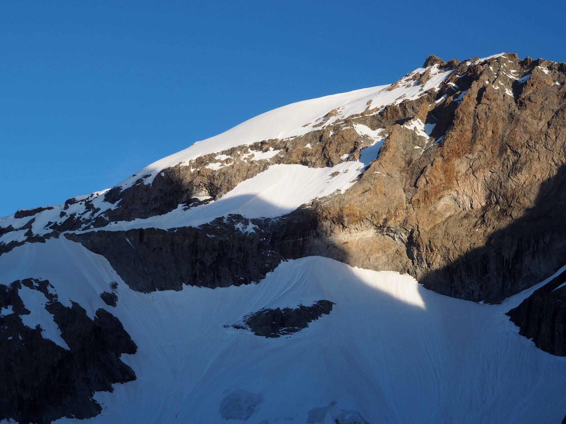 Réveil soleil sur le sommet Est du Râteau (3808m), juste au dessus du refuge