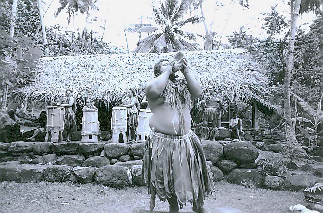 Maori soufflant dans une conque appelée localement pũ, faite avec une coquille de Charonia tritonis. Iles Marquises.