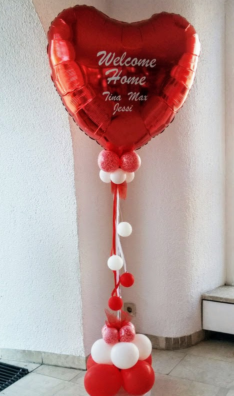 Mit Folienplott personalisierte "Welcome Home" Message auf riesigem roten Folienherzballon als Säule. Schriftart und Text wird als Unikat nach Ihrem Wunsch gefertigt. Bitte mindestens 3 Tage vorbestellen.