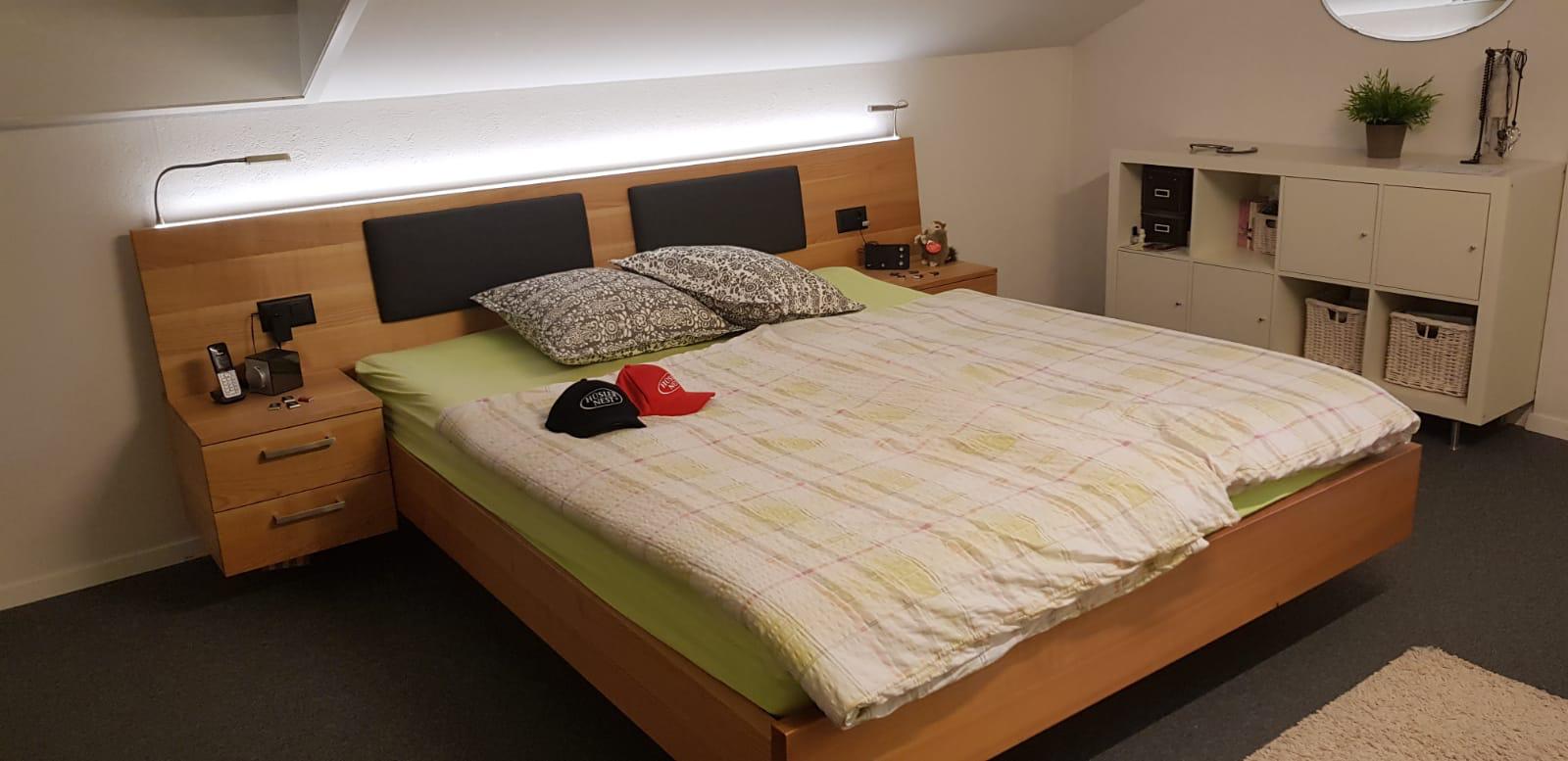 Kirschbaumbett mit indirekter Beleuchtung sowie Kopfteilpolstern